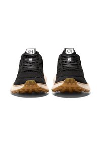 Černé pletené sportovní boty s béžovou gumovou podrážkou, s texturovaným svrškem, plochými tkaničkami a logem na jazyku.