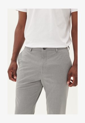 Pantaloni gri, ajustați, cu un finisaj texturat, prezentând buzunare frontale, încheiere cu nasture și o croială adaptată. Asortați cu un tricou alb.