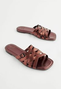 Metallisk brune slingback sandaler med firkantet tå og krydset stropdesign. Glat tekstur med en lav hæl og justerbar spænde.