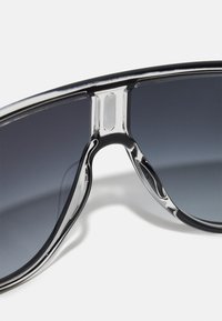 Silmad prillid stiilse musta plastraamiga, gradient tumedate objektiividega ja läikivate hõbedaste aksessuaaridega sillal. Sile tekstuur, ümberpööratud disain.