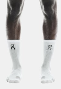 Calze sportive bianche con texture a coste e logo nero. Design fino al ginocchio con punta e tallone rinforzati per una maggiore durata.