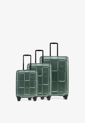 Drei grüne Hartschalenkoffer in unterschiedlichen Größen. Sie haben ein strukturiertes geometrisches Muster, schwarze Teleskopgriffe und Drehrollen.