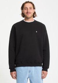 Sort sweatshirt lavet af bomuld med rund hals, løs pasform og ribbede manchetter. Har et lille hvidt logo på venstre bryst.