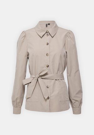 Beige button-up shirt jacket with a collar, long puff sleeves, and a tie belt at the waist. Features two front pockets and brown buttons.
