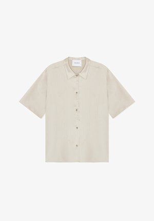 Chemise beige à manches courtes avec col, en tissu subtilement texturé et cinq boutons à l'avant.