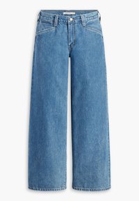 Blå högmidjade vida jeans i denim med framknapp, bälteshällor och snedställda framfickor på en vit bakgrund.