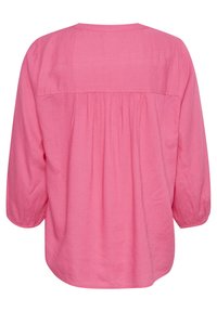 Chemise ample à manches longues en lin rose vif, ourlet arrondi, détail froncé à l'arrière, avec une texture subtile.