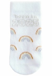 Chaussette blanche de cheville présentant des motifs multicolores en arc-en-ciel et un texte "né en 2023" en gris clair. Fabriquée en tissu doux et extensible.