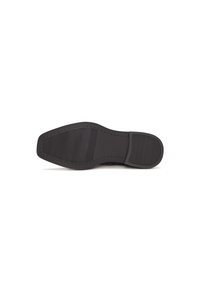 Semelle de chaussure noire avec des motifs de grip texturés sur les zones des orteils et du talon, présentée sur un fond blanc.