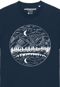 T-shirt bleu marine avec un design graphique blanc représentant des montagnes, des arbres et un lac avec une lune croissante, le tout contenu dans une bordure circulaire. Matière en coton.