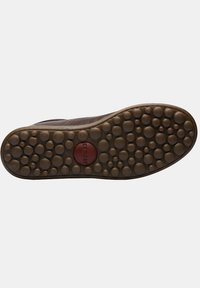 Brown rubber shoe sole with a rounded pattern, featuring a red circular detail marked "camper" in the center. Textured and durable design.