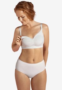 Valkoinen puuvillabralette, jossa on säädettävät hihnat, teksturoitu kangas ja rypytys yksityiskohtina. Yhdistetty samankaltaisiin korkeavyötäröisiin pikkuhousuihin.