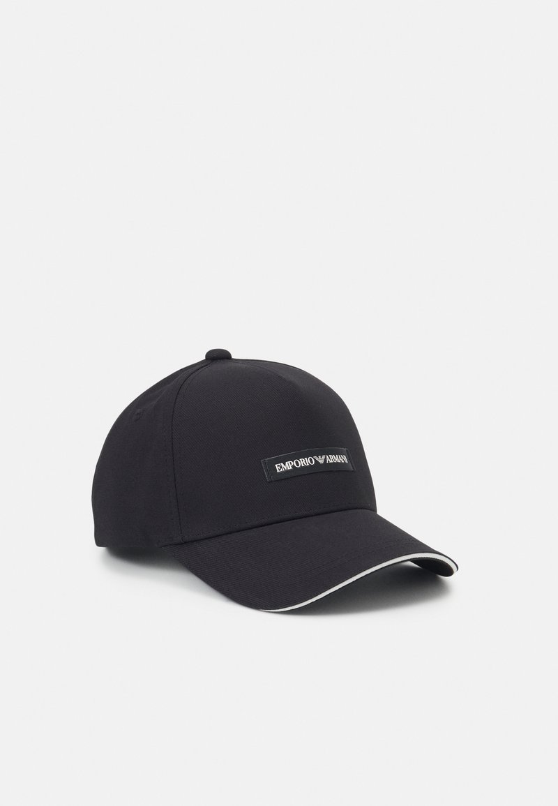 Casquette de baseball noire en tissu avec une visière courbée. Présente des coutures blanches en accent et un patch logo rectangulaire à l'avant.