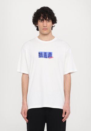 White cotton t-shirt featuring a blue graphic print of pagoda silhouettes and text, with short sleeves and a relaxed fit.