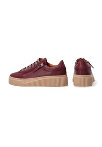 Burgunderfarbene Leder-Sneaker mit einer strukturierten beigen Plateau-Sohle. Ausgestattet mit silbernen Ösen und einem seitlichen Reißverschluss für leichtes An- und Ausziehen.