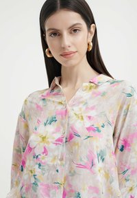 Blumen-Baumwollhemd aus leichtem Stoff, mit rosa, gelben, weißen und grünen Mustern. Klassischer Kragen und entspannter Schnitt.