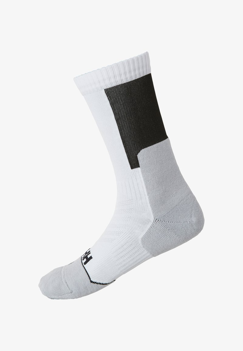 Calcetín deportivo en blanco con acentos en negro, que cuenta con un puño acanalado, talón reforzado y una costura lisa en la puntera. Fabricado con material transpirable.