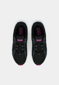 Baskets de sport noires avec accents gris, tige en mesh, lacets noirs, bout arrondi et logo rose. Semelle texturée pour une meilleure adhérence.