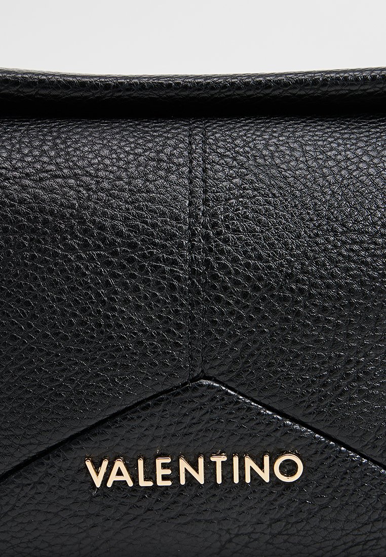 Surface en cuir noir texturé avec des coutures visibles et le logo en lettres dorées de Valentino centré sur le matériau.