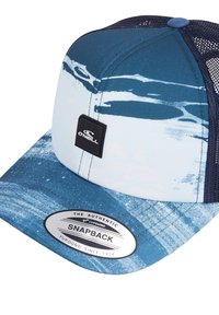Sinine ja valge snapback müts, millel on võrkpaneel. Omab värvi sarnast mustrit, musta logoga lipikut ja hõbedast bränditud kleebist visiiril.
