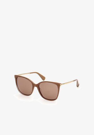 Brown cat-eye sunglasses with tinted lenses and slim gold temples resting on a white surface.