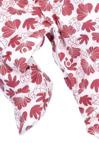 Witte baby voetenslaapzak met rode en roze bloembladpatronen en drukknoopjes langs de benen en het kruis.