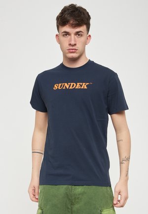 Maglietta blu navy in cotone, con colletto a giro e maniche corte. Sul davanti è stampato il logo in grassetto "SUNDEK" di colore arancione.