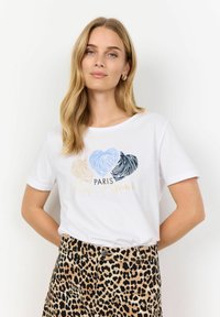 Witte t-shirt met korte mouwen, voorzien van gekleurde vingerafdruk-achtige harten en de tekst "PARIS Mon Amour". Gepaarde met leopardprint broek.