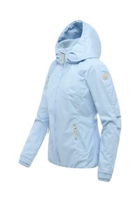 Veste à capuche bleu clair pour femme avec fermeture éclair à l'avant, poches latérales zippées, poignets élastiques et un logo circulaire sur la manche gauche.