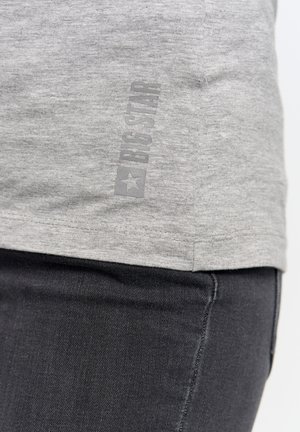 Pelēks kokvilnas T-krekls ar smalku "BIG STAR" logo, kas drukāts vertikāli pelēkā krāsā. Krekls ir ar īsām piedurknēm un mīkstu tekstūru.