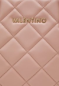 Różowa skórzana pikowana z złotym brandingiem "VALENTINO", o gładkiej teksturze i diamentowym wzorze.