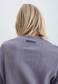 Lavender-farbenes Fleece-Sweater mit geripptem Halsausschnitt und Rückenetikett-Detail. Weiche Textur mit einem lässigen, lockeren Schnitt.