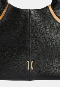 Borsa a tracolla in pelle nera con finitura testurizzata, caratterizzata da un accento in pelle beige liscia, accessori in metallo dorato e un logo impresso sul davanti.
