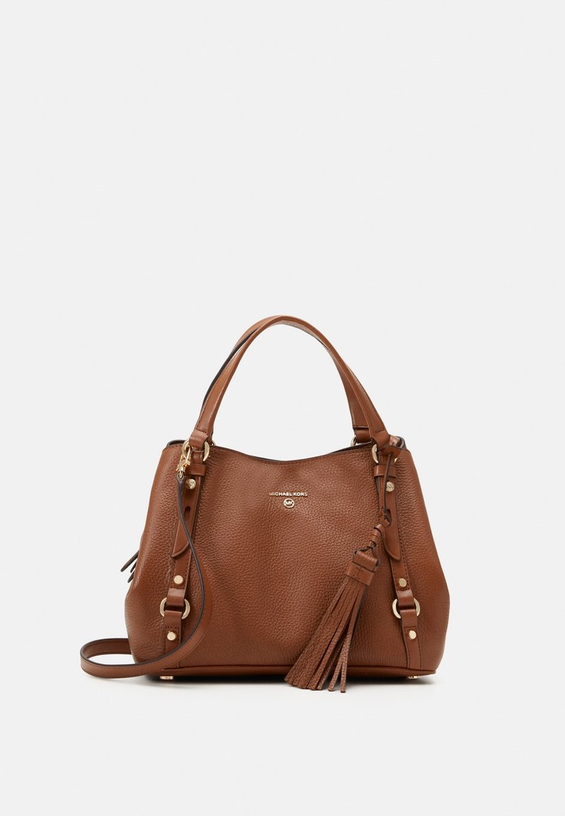 Sac à main en cuir grainé marron avec deux poignées supérieures, bandoulière amovible, ferrures dorées et un pompon décoratif.