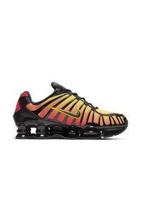Black and yellow Nike sneakers with gradient orange-red accents, mesh upper, gripping sole, and distinctive SHOX cushioning system.