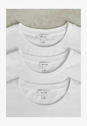 Tri bele bombažne majice z ovalnimi izrezom, zložene skupaj, z obdelavo šivov. Oznake vsebujejo napis "REISS" in velikost "M." Klasična zasnova.