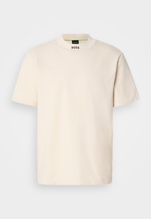 Crème kleurig T-shirt met korte mouwen en hoge kraag, met "BOSS" in het zwart gedrukt op de voorkant van de nek en op het binnenlabel.