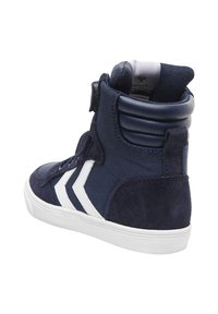 Marina högskor med ovandel i mocka och textil, vita chevron detaljer, vadderad krage och gummisula. Har robusta snören.