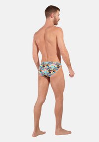 Swim trunks with a colorful floral print, made from stretchy fabric. Features a fitted design with a mid-rise waist.