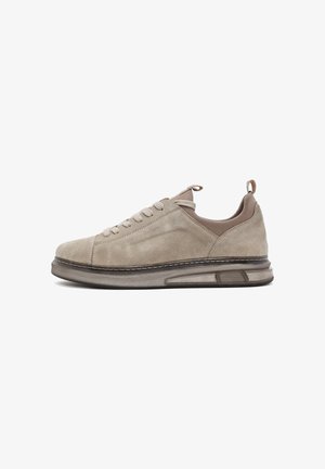 Baskets en suède beige avec fermeture à lacets à l'avant, languettes de traction sur la languette et le talon, et semelle coussinée translucide pour le confort et le maintien.