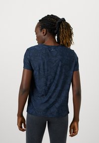 Marineblå t-shirt med kortærmer, der har et struktureret slangeskindsdesign. Blødt stof med en afslappet pasform og rund halsudskæring.