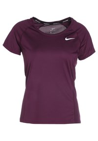 Fioletowa sportowa koszulka z krótkim rękawem i siateczkową wstawką przy dekolcie, z białym logo Nike w kształcie haczyka z przodu. Gładka tekstura tkaniny.