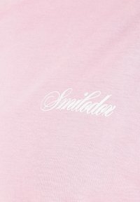 Tissu rose clair avec texte blanc en cursive "Smilodox" imprimé sur la surface.