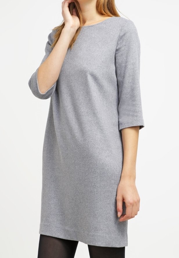 Grå stickad klänning med rund halsringning och trekvartslånga ärmar. Mjuk textur, rak passform och fåll som slutar ovanför knäna.