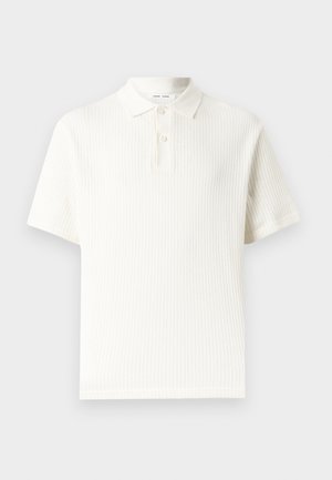 Λευκό πουλόβερ πόλο με κοντά μανίκια, υφή με μοτίβο και πλάκα με δύο κουμπιά σε απλό φόντο.