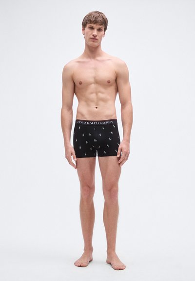 Schwarze Boxer mit einem Taillenbund mit Logo, der ein sich wiederholendes kleines Pony-Muster in Weiß zeigt. Hergestellt aus weichem Stoff, figurbetontes Design.