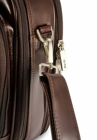 Brązowa skórzana torba z metalowymi, srebrnymi elementami, suwakami oraz odpinanym paskiem. Charakteryzuje się gładką fakturą i kontrastującym przeszyciem.