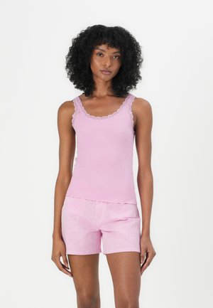 Lys pink ribbet tanktop med blonder trim, parret med shorts i pink og hvid strib. Blødt stof, tætsiddende design og scallop-kant på shortsene.