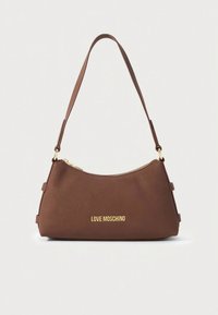 Barna műbőr kézitáska ívelt formával, arany logó díszítéssel és állítható pánttal. Cipzárral záródik a tetején.