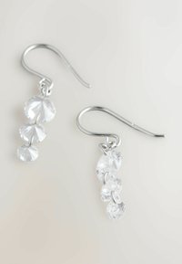 Hõbedast konksuga kõrvarõngad, kus on kolm läbipaistvat, ümmargust, lõhestatud vääriskivi, mis on järjestatud kahanevas suuruses, eksponeeritud heledal taustal.